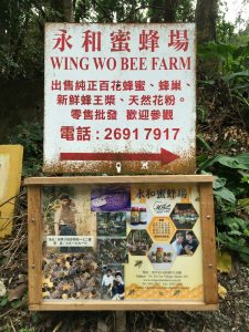 Signpost for Wing Wo Bee Farm, Sha Tin showing a man with a bee beard