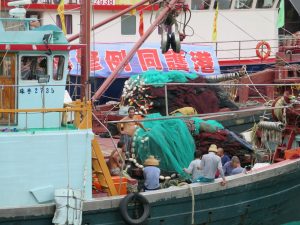 Fishermen at work on boat in Hong Kong.