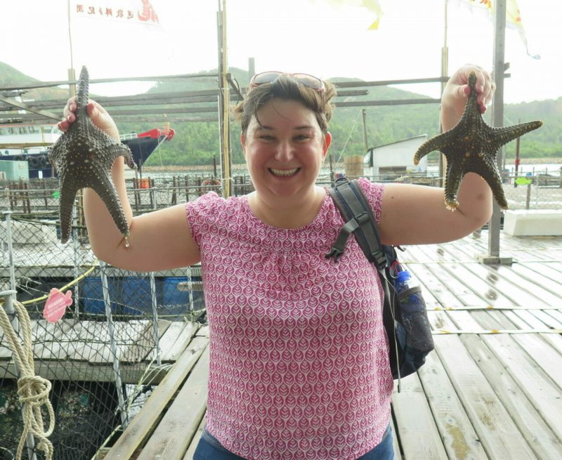 woman holding two starfish Lamma Island Rainbow Tour
