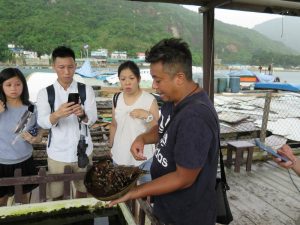 Tour guide holding horseshoe crab Lamma Island.
