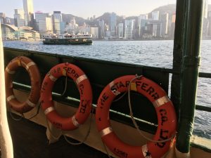 spollight on star ferry with Hong Kong skyline