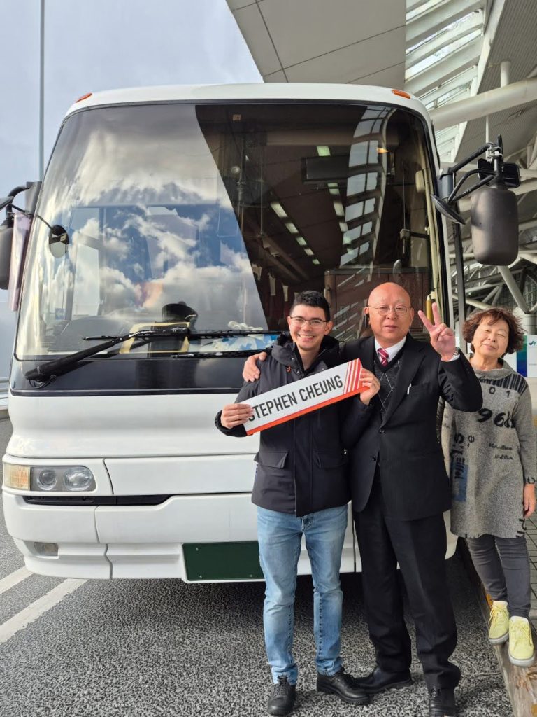 Hong Kong private tour guide Stephen welcoming guests beside their charter coach