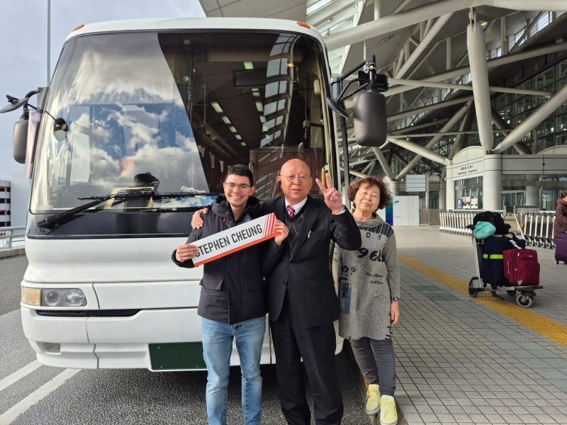 Hong Kong private tour guide Stephen welcoming guests beside their charter coach