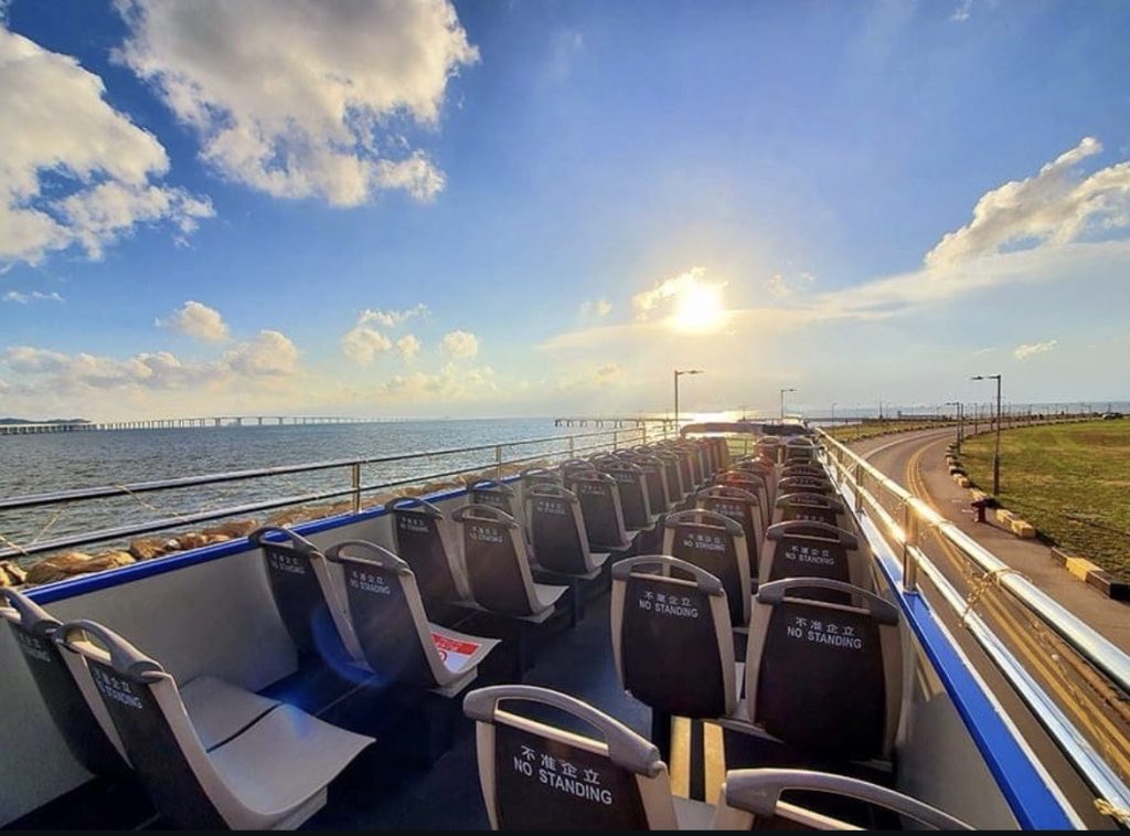 Open-top private tour bus travelling along the Hong Kong waterfront